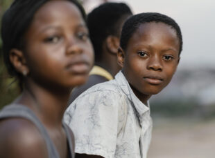 Two children in foreground, one looking at camera