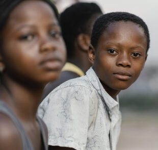 Two children in foreground, one looking at camera
