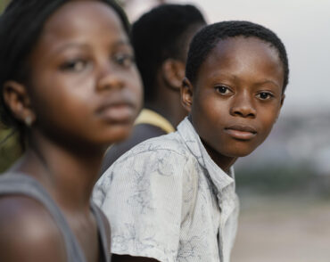 Two children in foreground, one looking at camera
