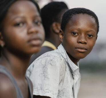 Two children in foreground, one looking at camera