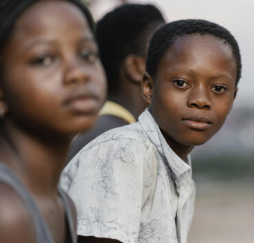 Two children in foreground, one looking at camera