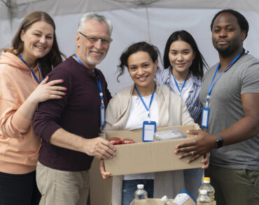 Volunteers holding food box at donation drive