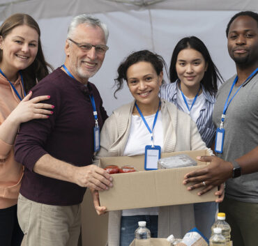 Volunteers holding food box at donation drive